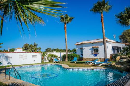 uma piscina em frente a uma casa com palmeiras em Casas Dibaca by El Palmar em El Palmar