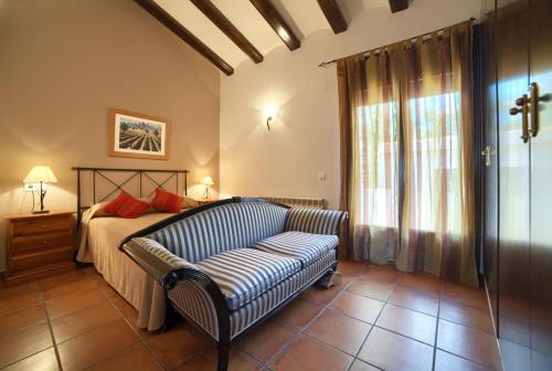 1 dormitorio con cama, sofá y ventana en Casa Rural El Olmo en Gúdar