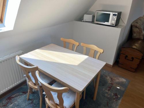 a table and chairs in a room with a microwave at Schwalbennest - Fewo 2 in Nordstrand