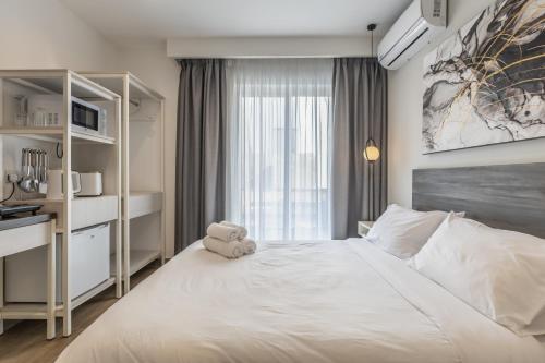 a bedroom with a white bed with a teddy bear on it at Studio 23 with kitchenette at the new Olo living in Paceville