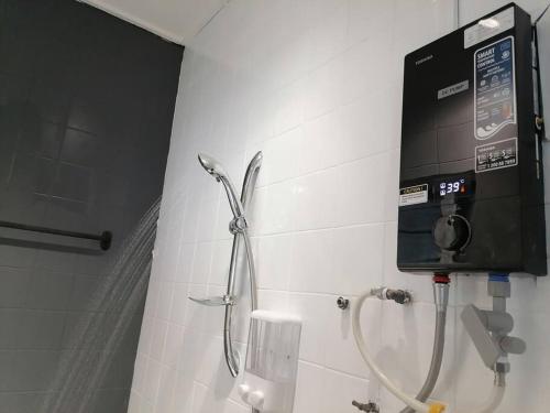 a shower in a bathroom with a dispenser on the wall at Petaling Jaya SS2 Seapark Landed House, 4BedRoom, for 12 Pax with Netflix in Petaling Jaya