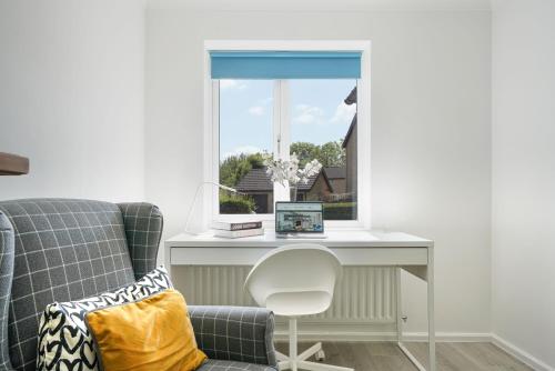 a room with a desk and a chair and a window at Detached House - Close to City Centre - Free Parking, Fast Wifi, Private Garden and Smart TV with Netflix by Yoko Property in Milton Keynes