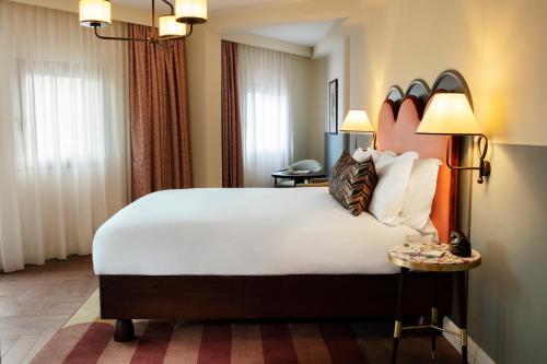 a hotel room with a large bed and two lamps at The Hoxton, Charlottenburg in Berlin