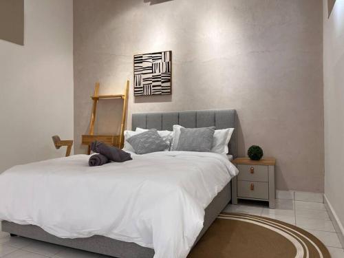 a bedroom with a large bed with white sheets at Petaling Jaya SS2 Seapark Landed House, 4BedRoom, for 12 Pax with Netflix in Petaling Jaya