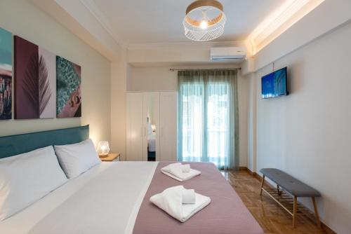 1 dormitorio con 1 cama grande y 2 toallas. en Blue Ark Wanderlust, en Atenas