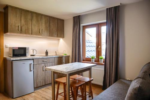a small kitchen with a table and a counter at DW Pod Jaworami - relaks - jacuzzi, sauna na wyłączność in Białka Tatrzanska