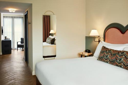 a hotel room with a large bed and a bedroom at The Hoxton, Charlottenburg in Berlin