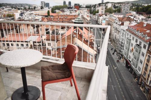 a balcony with a table and chair and a view of a city at Hotel City View Deluxe in Sarajevo