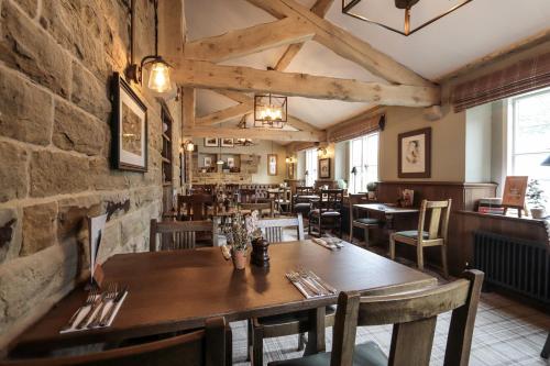 uma sala de jantar com uma mesa de madeira e cadeiras em The Tempest Arms em Skipton