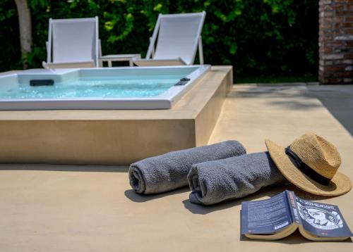 - une paire de serviettes et un chapeau à côté d'un bain à remous dans l'établissement Oikies Small Elegant Houses, à Mytilène