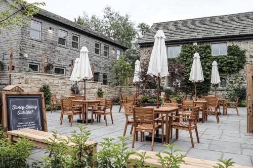 un patio con mesas y sombrillas blancas en The Tempest Arms en Skipton