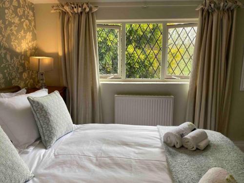 ein Schlafzimmer mit einem Bett mit zwei ausgestopften Tieren darauf in der Unterkunft Luxury Cottage in Somerset in Wiveliscombe