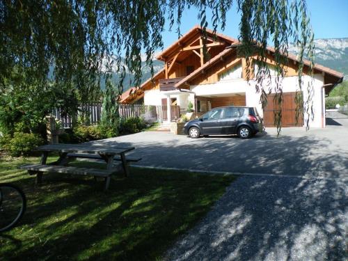 a car parked in front of a house with a picnic table at Gîte Annecy 06 - Au Royaume des Marmottes - Appt 06 in Doussard