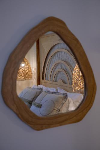 a reflection of a bed in a round mirror at Oikies Small Elegant Houses in Mytilini