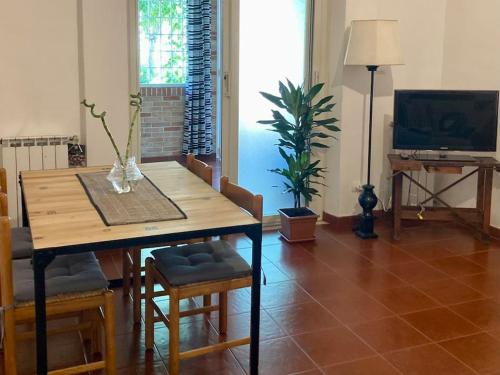 un salon avec une table en bois et une télévision dans l'établissement Chez Nous, à Ladispoli
