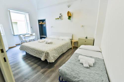 sypialnia z 2 łóżkami i oknem w obiekcie Welcome Varigotti - Borgo Saraceno - Scirocco w mieście Varigotti