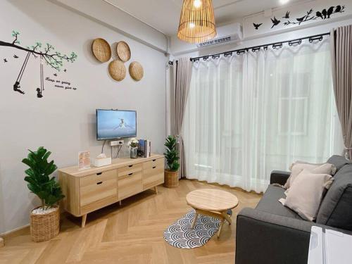 a living room with a couch and a tv at Unwind in oldtown, private floor, near Grand Palace in Bangkok