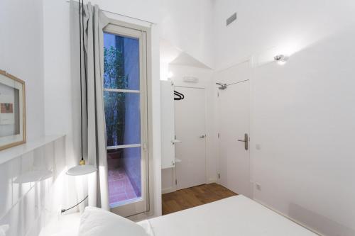 a white room with a window and a bed at Hostal Argo in Barcelona