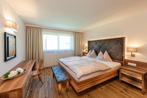 1 dormitorio con cama grande y escritorio de madera en Weingut Eichenstein, en Merano