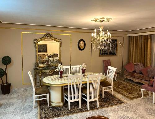 ein Esszimmer mit einem Tisch, Stühlen und einem Spiegel in der Unterkunft Luxury Apartment 2 Nasr City- City stars in Kairo