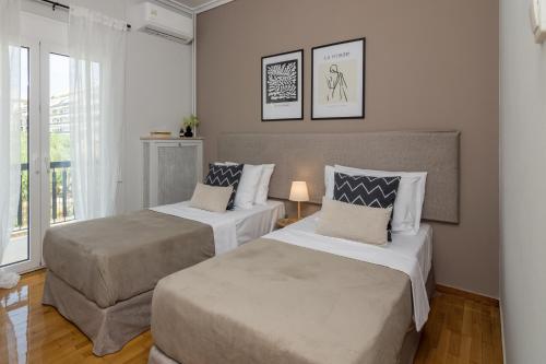a bedroom with two beds and a window at Spacious 2 Bedroom Apartment In Koukaki in Athens
