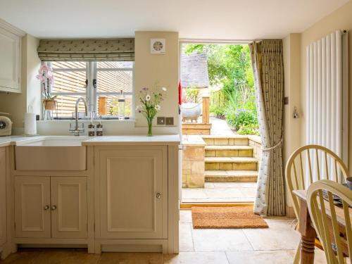 a kitchen with a sink and a door to a yard at High Pump Cottage in Chipping Campden