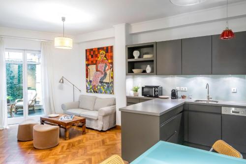 a kitchen and living room with a couch and a table at Central Athenian 1BR Apartment in Athens