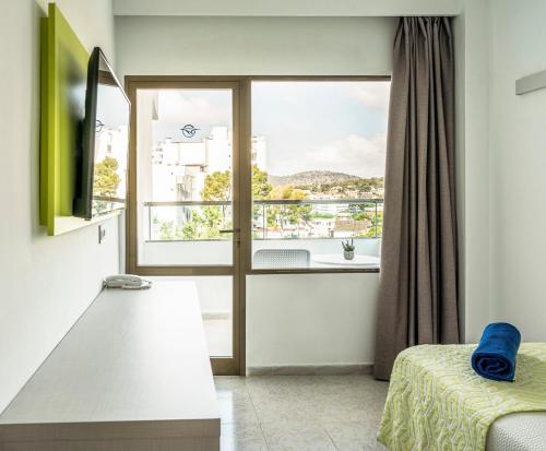 a room with a bed and a large window at Globales Torrenova in Magaluf