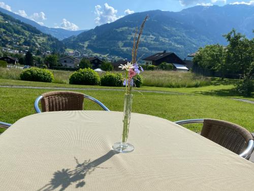 a table with a vase with a flower in it at AlpenApart Montafon - Haus Engstler in Schruns-Tschagguns