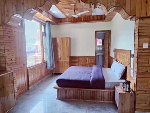 a bedroom with a bed and a large window at Delight Homestay Kasol in Kasol