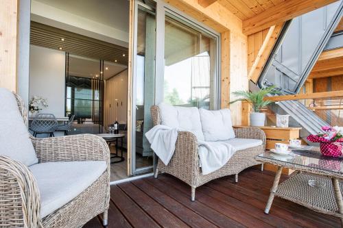 a porch with wicker chairs and a table at Apartamenty Royal Resort & Spa in Zakopane