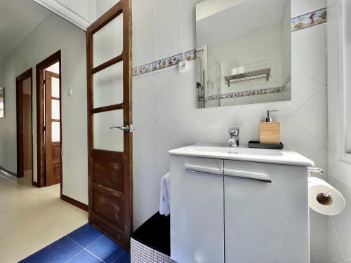 a white bathroom with a sink and a mirror at Green Door Coruña in A Coruña
