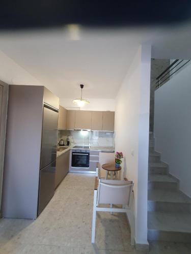 a kitchen with a staircase and a table in a room at Momo's House in Nikiti