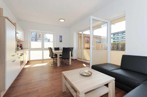 a living room with a couch and a table at Haus Leuchtturm in Bensersiel