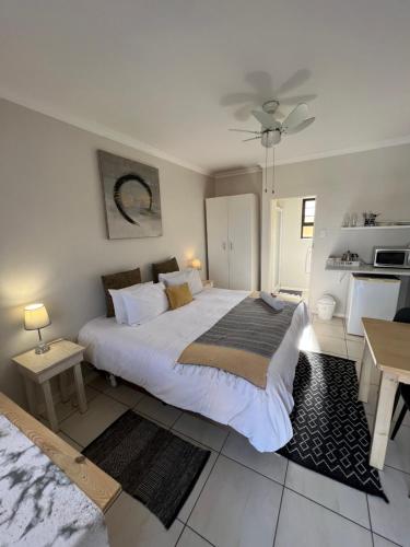 a bedroom with a large white bed and a table at 10 on Beresford in East London