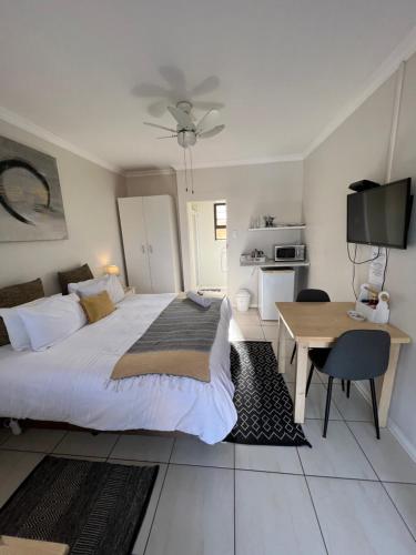 a bedroom with a bed and a table and a television at 10 on Beresford in East London