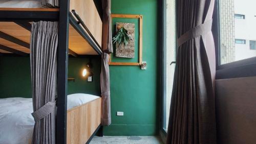 um quarto com 2 beliches e uma parede verde em 以安二館 em Lukang
