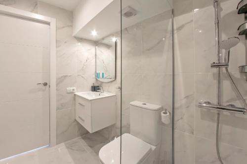 a bathroom with a shower and a toilet and a sink at Modern Studio with a Sea View and Pool Access Ponderosa 801 in Playa de las Americas