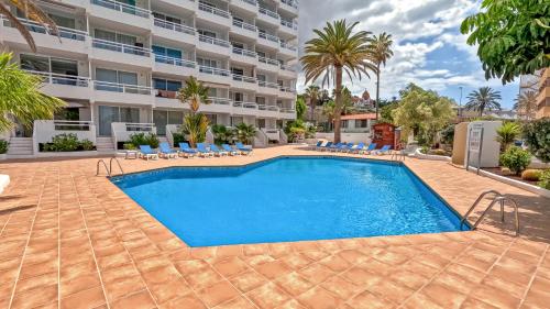 a swimming pool in front of a building at Modern Studio with a Sea View and Pool Access Ponderosa 801 in Playa de las Americas