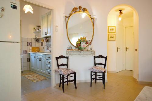 a kitchen with two chairs and a mirror at Villa Beatrice 25 in Siracusa