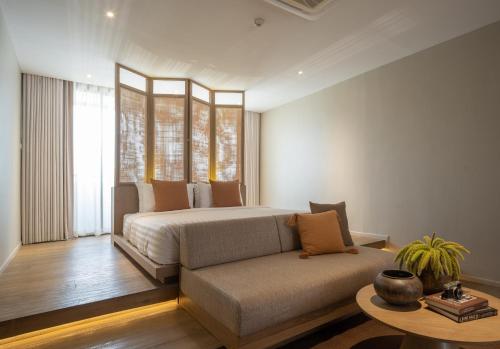 - une chambre avec un lit, un canapé et une table dans l'établissement Stay Plus Hotel Bangkok, à Bangkok