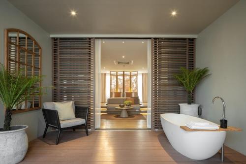 ein Badezimmer mit einer Badewanne, einem Stuhl und einem Sofa in der Unterkunft Stay Plus Hotel Bangkok in Bangkok