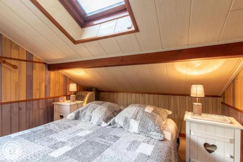 um quarto com uma cama e uma clarabóia em Gîte Annecy 07 - Au Royaume des Marmottes - Appt 07 em Doussard