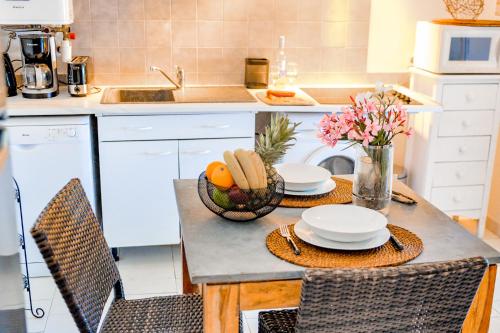 eine Küche mit einem Tisch und einer Obstschale in der Unterkunft Sandra - Maison, Patio, Plage d'argent à 2 min - Verghia in Coti-Chiavari