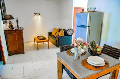 ein Wohnzimmer mit einem Tisch und einem Kühlschrank in der Unterkunft Sandra - Maison, Patio, Plage d'argent à 2 min - Verghia in Coti-Chiavari