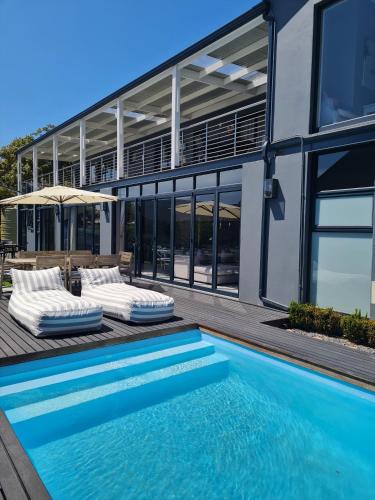 a house with a swimming pool next to a building at 2 On Lismore Guesthouse in Tokai
