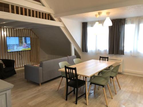 sala de estar con mesa de madera y sillas en Angers - L’appartement de Marius, calme et confort, en Angers