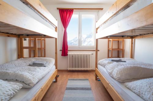 twee bedden in een kamer met een raam bij Hotel Schwarzsee in Zermatt
