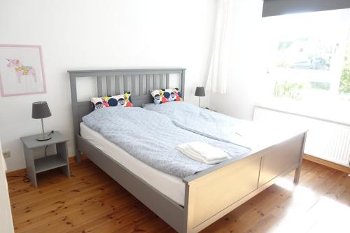 een slaapkamer met een groot bed met blauwe lakens en kussens bij Ferienwohnung im Kieler Süden in Kiel