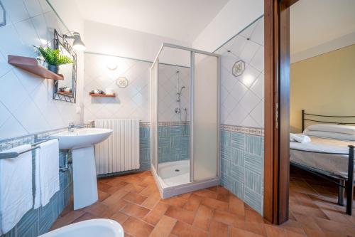 ein Bad mit einer Dusche, einem Waschbecken und einem Bett in der Unterkunft Casello A1, Modena sud - Villa Aurora Charming Rooms in Modena